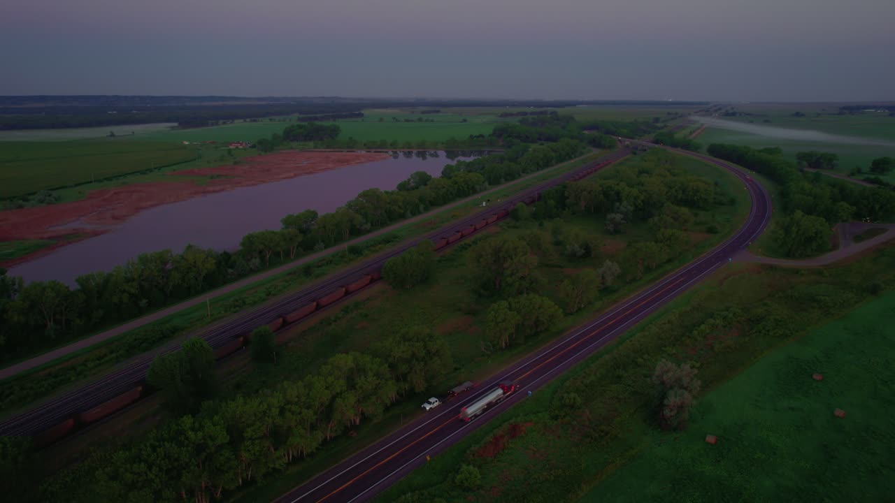 Drone view of road and railroad tracks with a stunning sunset skyline in Nebraska, United States