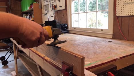 hombre usando lijadora automática en taller de madera