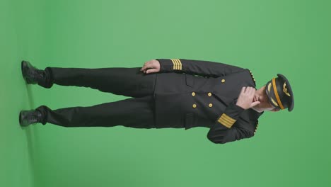 full body of asian man pilot having a headache while standing in the green screen background studio