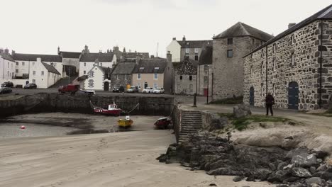 Portsoy-Harbour-lady-walks-along-quay-towards-town