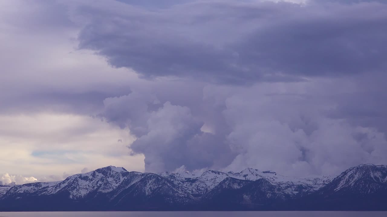 눈 덮힌 탈락 산과 캘리포니아 타호 호수 근처의 황폐한 황무지 뒤에 떠오르는 뇌우 구름 형성의 아름다운 시간 경과