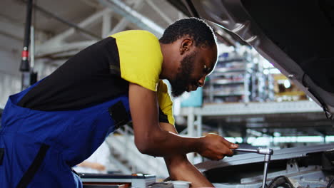 worker replaces car engine in garage