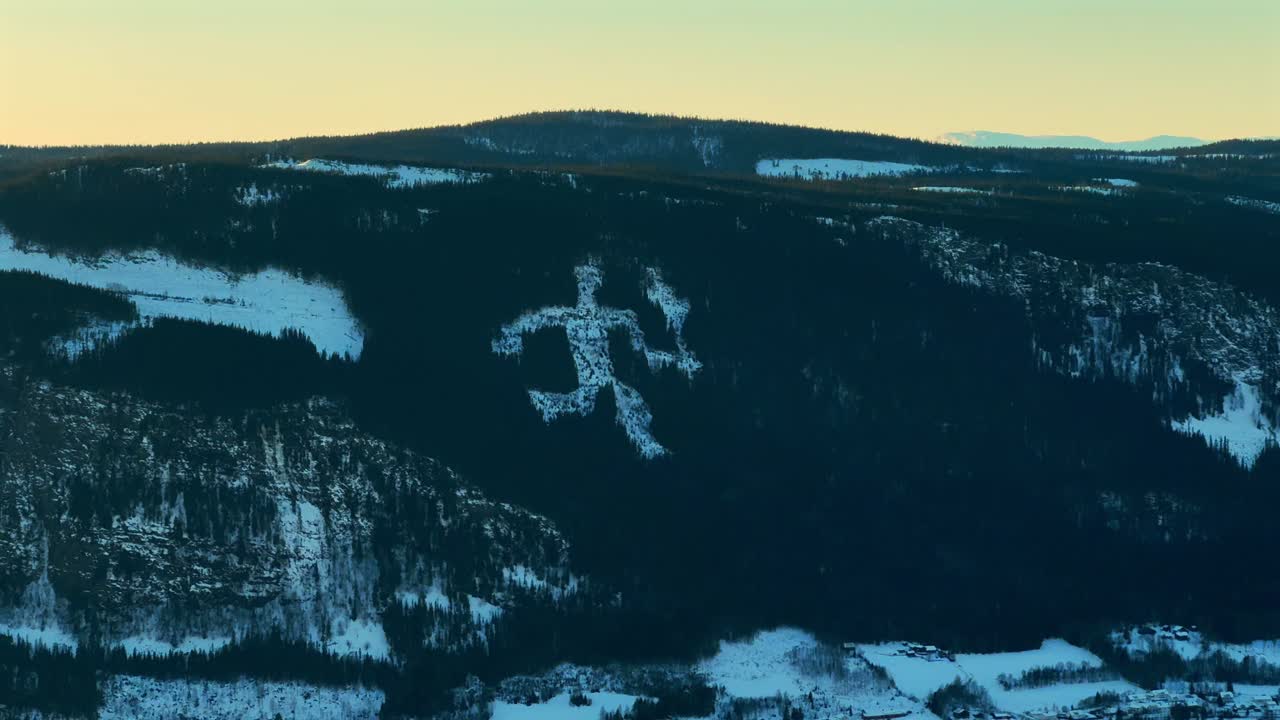 Lillehammer Fakkelmannen Olympic Torch Man on mountainside Hafjell Alpine Resort Norway Norge skiing down icy steep snow groomed trail run arctic winter sunset golden hour Øyer Sjusjoen pan left