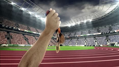 hand of athlete showing gold medals in olympic stadium