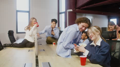 grupo de colegas multiétnicos bebiendo y pasando tiempo juntos en la fiesta de la oficina