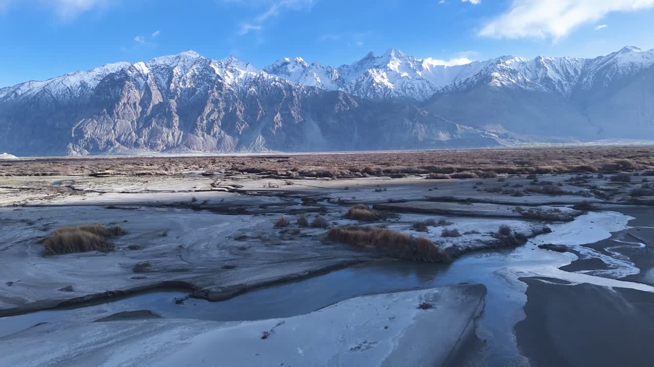 Aerial drone shot highlighting the rustic charm of Sumur village with prayer flags fluttering in the breeze.