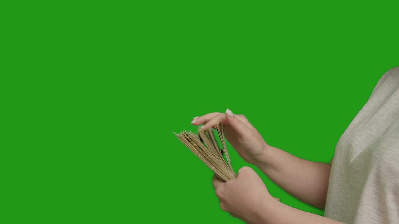 여자가 큰 돈 더미를 세고, 녹색 화면