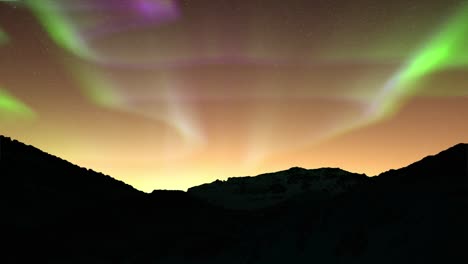 dark mountain peaks with colorful auroras in the sky