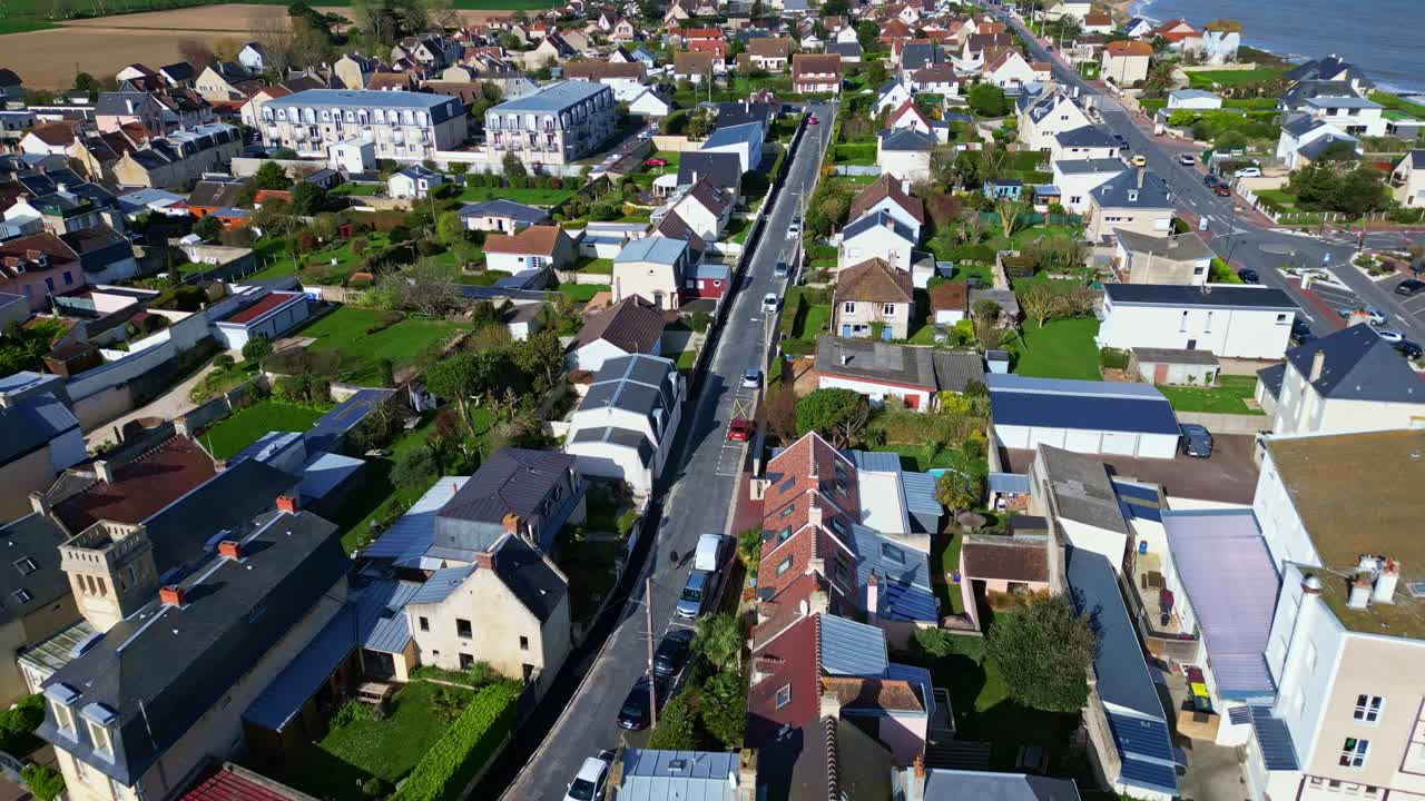 Gader og huse i Saint-Aubin-sur-Mer, en kystby i Normandiet, Frankrig, på en solskinsdag. Luftfoto fremad.