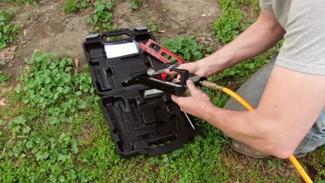 Man-assemble-pneumatic-nail-gun-for-working,-close-up-top-down-view