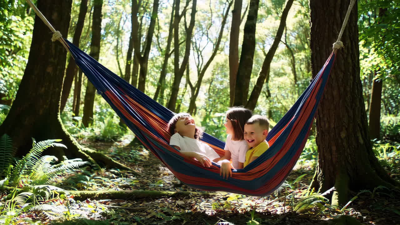 Children playing and laughing in a hammock in a sun-dappled forest