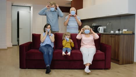 coronavirus quarantine lockdown concept. family puts medical protective masks on faces at home