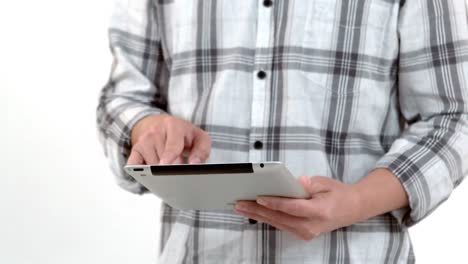 Mid-section-of-a-man-using-his-tablet