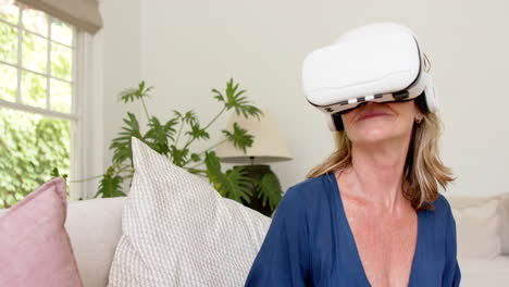 una anciana caucásica explora la realidad virtual en su casa.