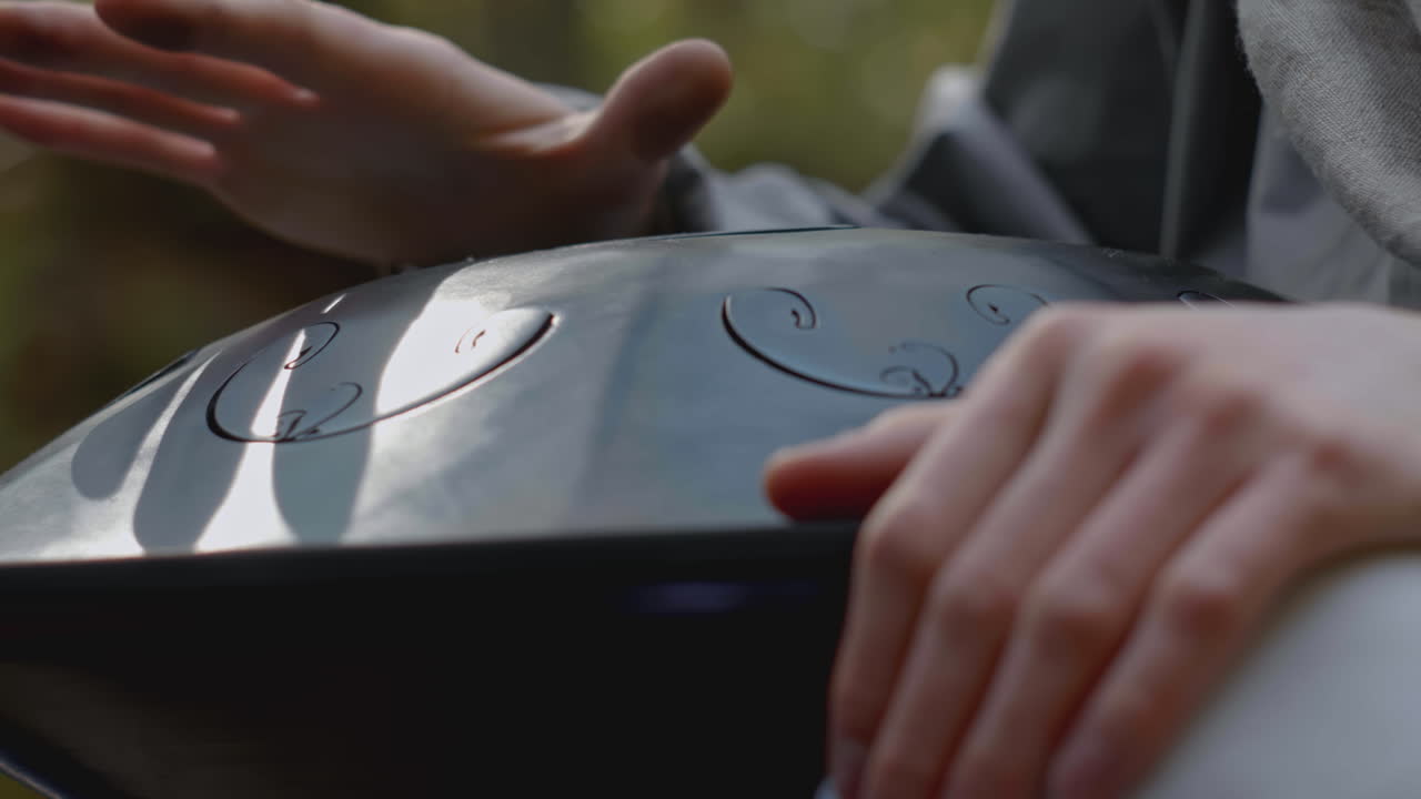 persona jugando a un handpan en el bosque