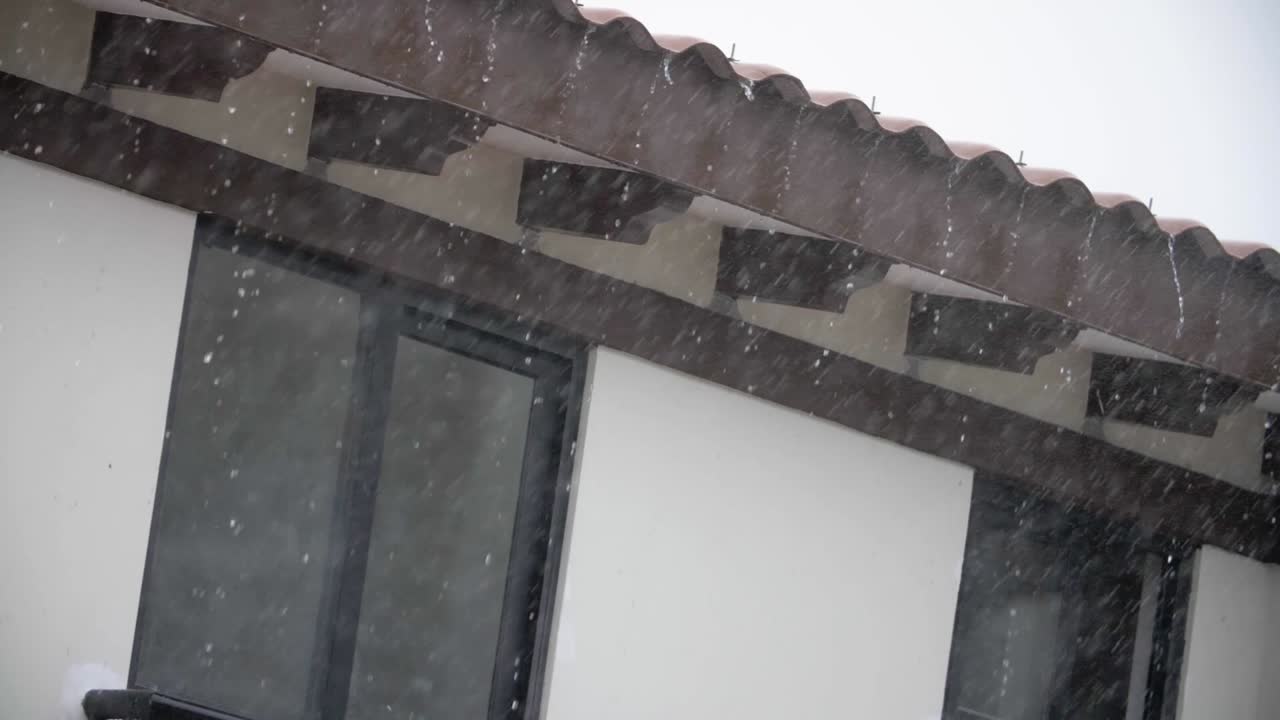 Rain falling in the roof of a house in a suburban setting - Slowmotion