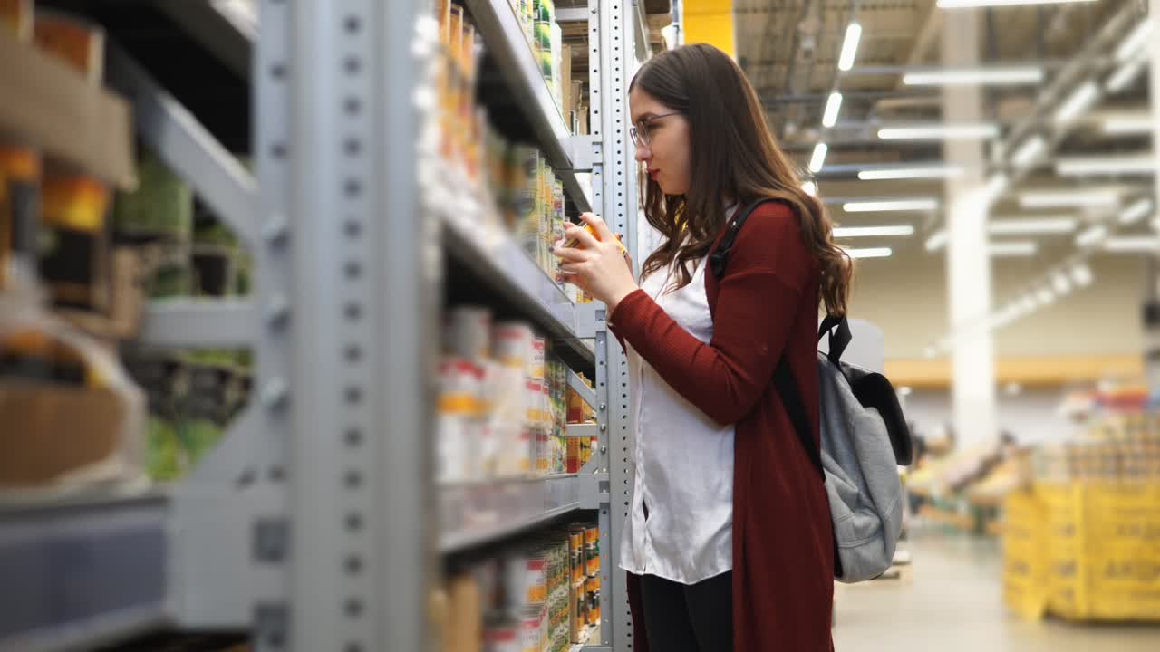 Woman Shopping for Canned Goods in a Grocery Store