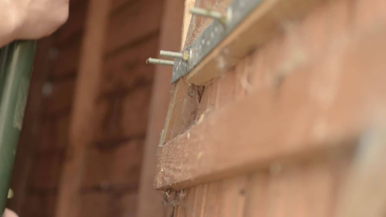 창고 문에 원예 손 도구를 거는 여자