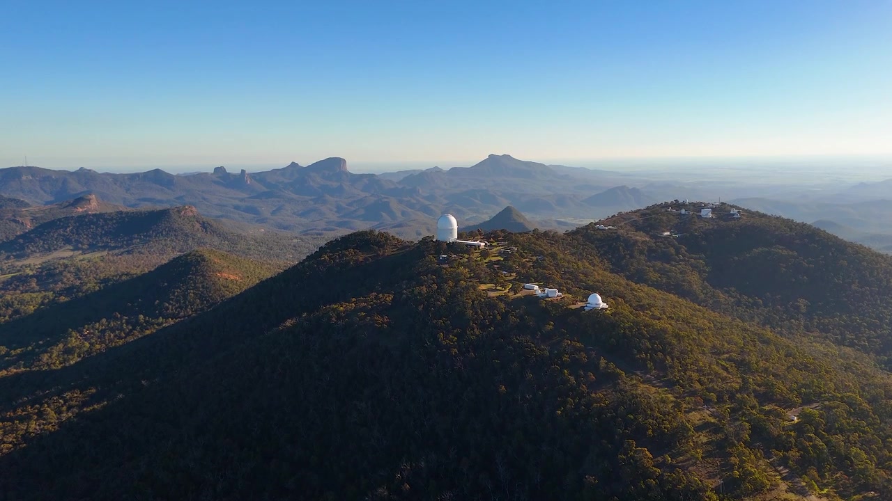 Vista aérea panorâmica de cúpulas de telescópios no topo de montanhas no Parque Nacional Warrumbungle, Austrália
