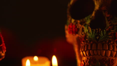 close up on still life of decorated skulls lit by candles celebrating mexican holiday of dia de muertos or day of the dead 7