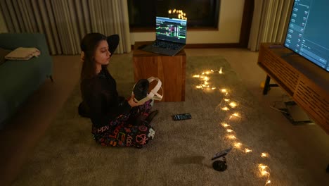 mujer relajándose en casa con auriculares vr y portátil