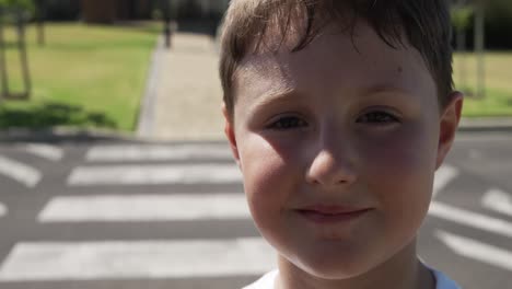 Boy-smiling-while-standing-on-the-road