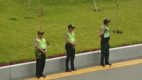 three police officers standing on a street