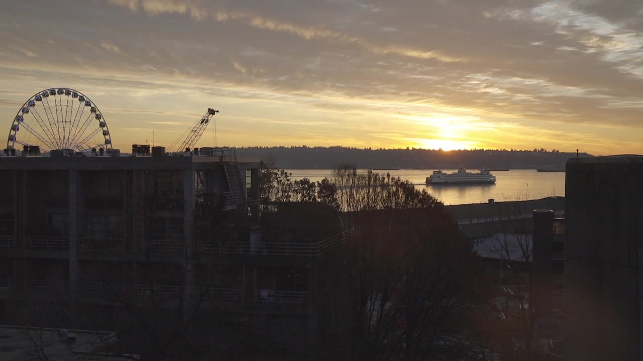 푸게트 사운드 (puget sound) 는 해가 지면 페리 (ferry) 의 건물들 사이의 전망이다.