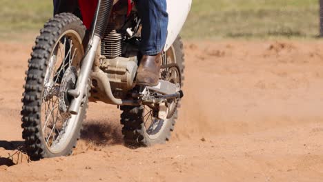 motorcyclist performs stunts on dirt track