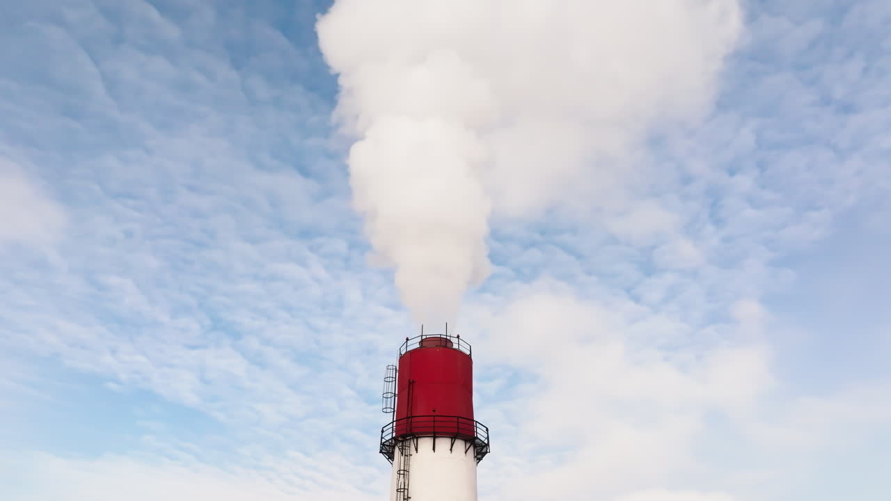 Aerial drone view of a working thermal power station. Steam and smoke coming from pipes