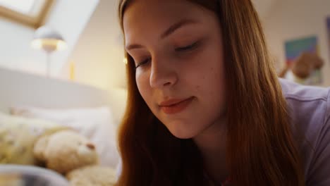 una adolescente usando un teléfono inteligente en su dormitorio