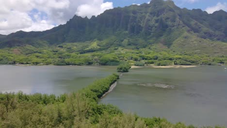 aerial shot of kane'ohe bay and the moli'i fish pond and mountains against the sky