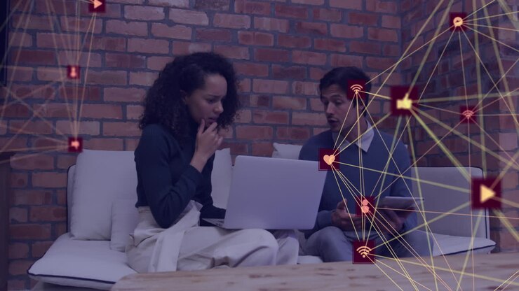 Animation of globes of digital icons spinning against diverse man and woman discussing at office