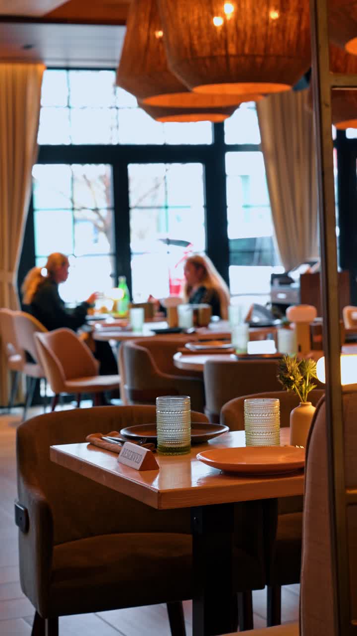 New York, USA, 8. april 2026: Reserveret bord i moderne restaurantinteriør. Selektivt fokus på et træbord med et reserveret skilt, glas og et sløret spiseområde i baggrunden.
