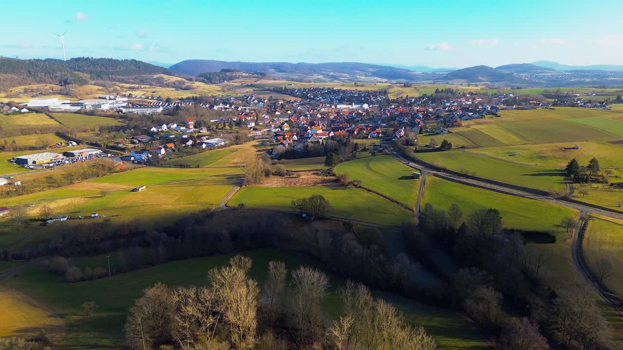Vista aerea di un villaggio esteso tra terreni agricoli verdeggianti