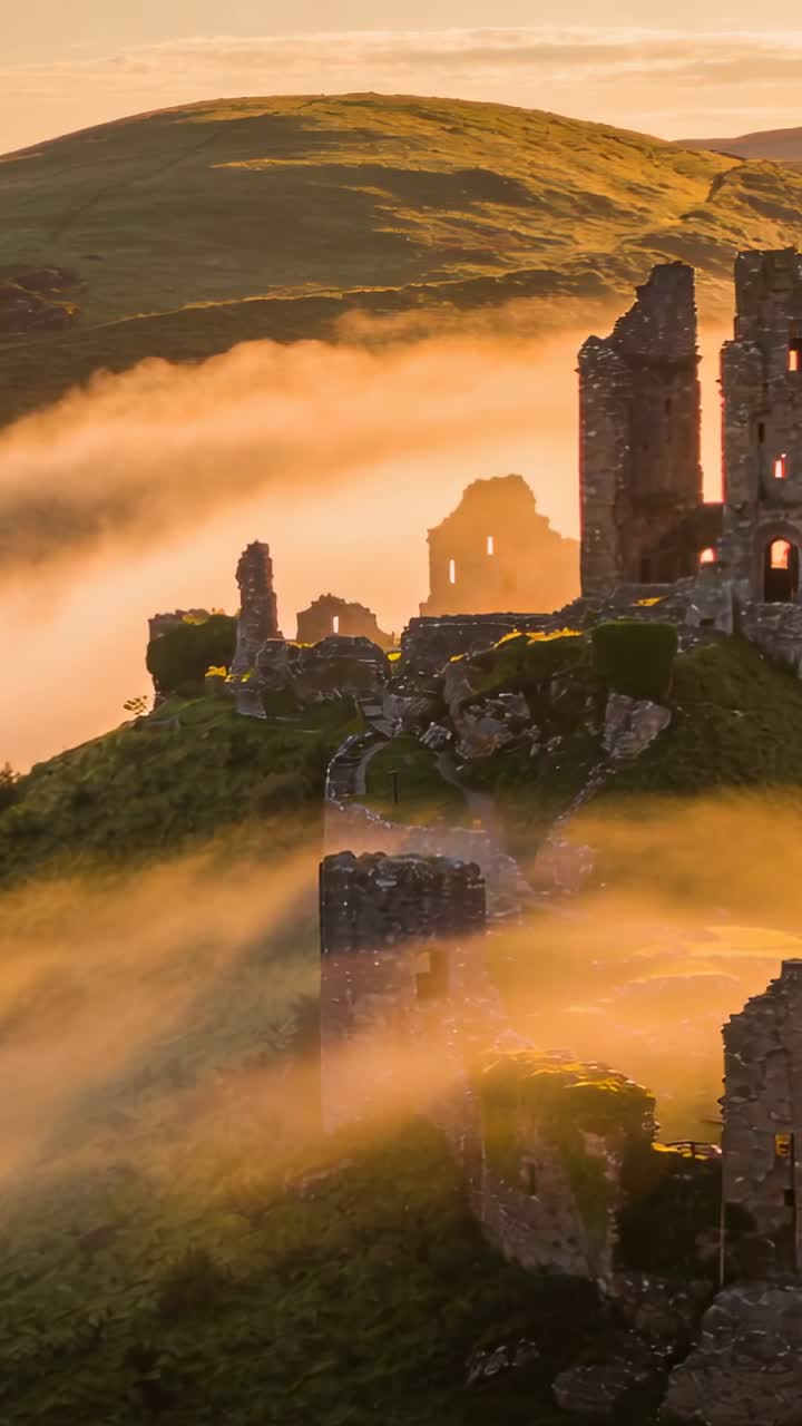 Video verticale: Luce dell'alba che causa la deriva della nebbia, rovine del castello che rivelano finestre per riprese cinematografiche.