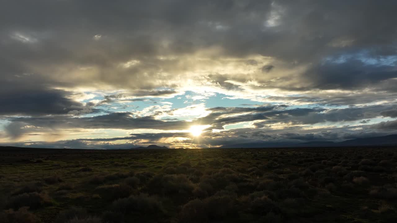 Sunset over the Mojave with clouds casting shadows on the desert floor, hints of blue sky
