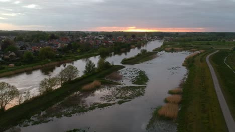 Vista-Aérea-Panorámica-Del-Pantano-Y-Las-Casas-En-Segundo-Plano-Al-Atardecer