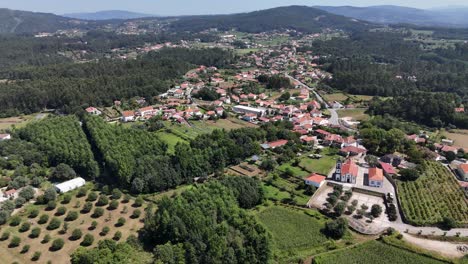 aerial - igreja paroquial de freixo, lush farmlands, hills, and village homes