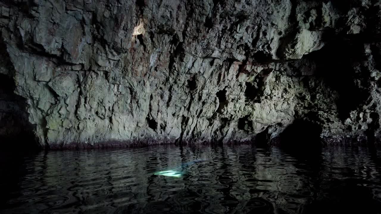 escena misteriosa dentro de una cueva marina con un rayo de luz que baja del techo y se refleja en una pared, isla de vis, mar adriático, croacia