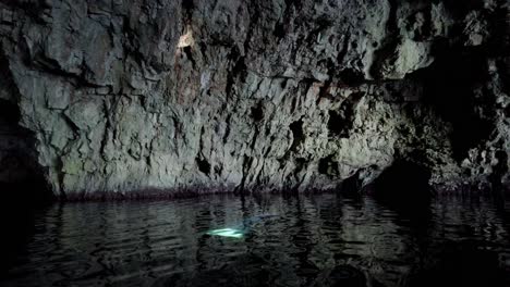 mysterious scene inside a sea cave with a ray of light coming down from the ceiling and reflecting on a wall, vis island, adriatic sea, croatia