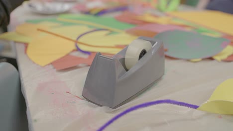 kids and adults in a daycare creating crafts with assorted materials.