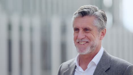 portrait of a smiling mature man with grey hair and a beard