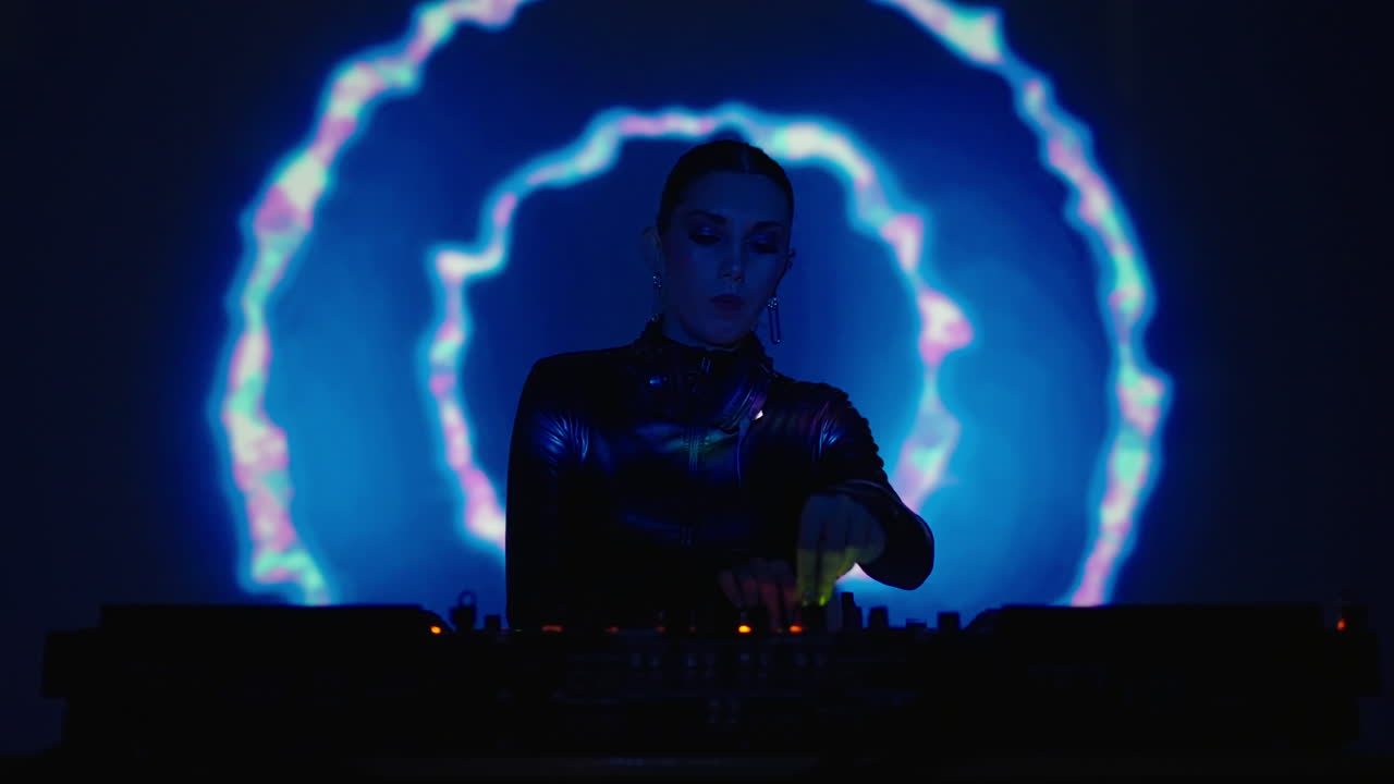 dj femenina actuando en un club nocturno con iluminación azul y púrpura