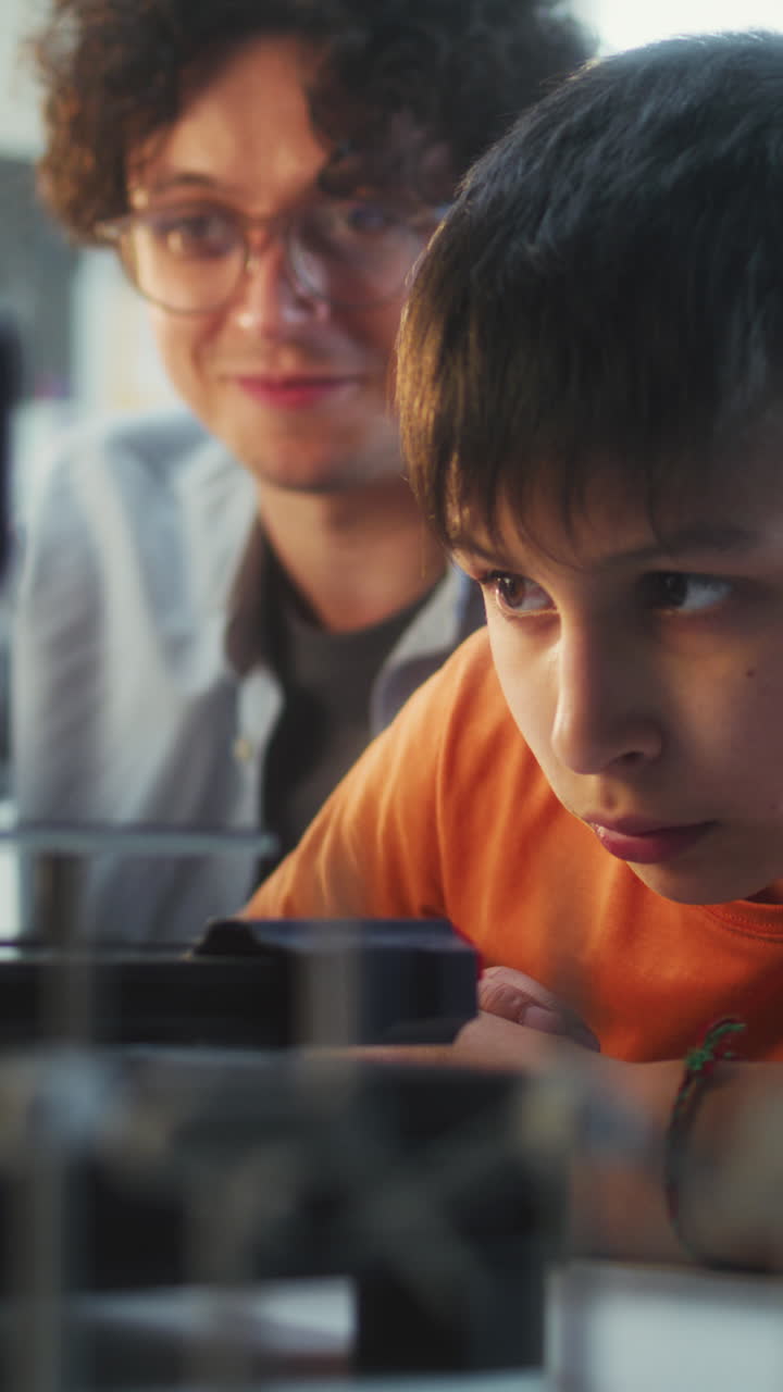 Student and Teacher Working on 3D Printer