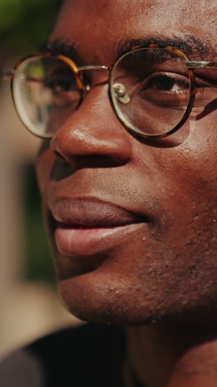A close-up portrait of a man with glasses