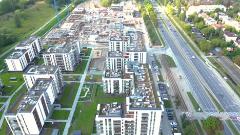 aerial bird eye view of a construction site building cranes looking down industrial machinery area around residential urban apartments