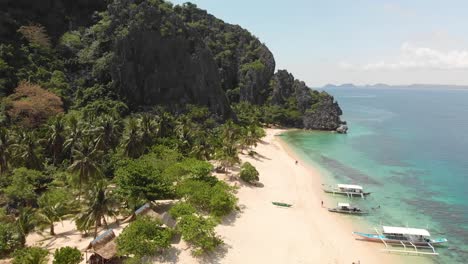 aerial drone shot towards paraw boats, on a beach, at clear, tuquoise water, at black island, in philippines, asia