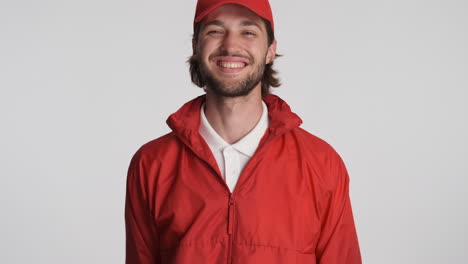 Caucasian-delivery-man-in-front-of-camera-on-white-background.