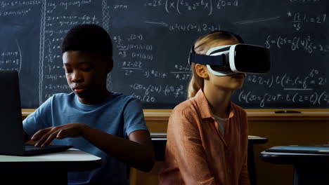 children learning with virtual reality and laptops in a classroom setting